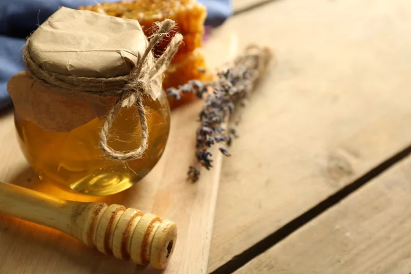 Glas mit Honig, Waben und Nüssen auf Holzgrund — Stockfoto