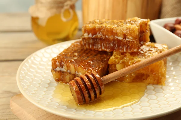 Pentes de mel na placa no fundo de madeira — Fotografia de Stock