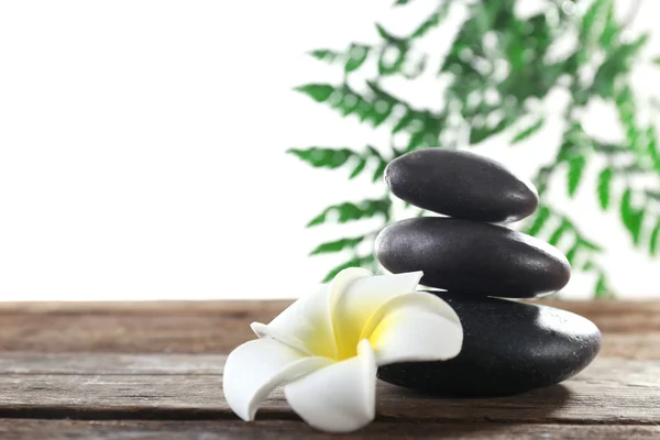 Spa taşları, bir mum ve üzerinde beyaz izole bir lotus — Stok fotoğraf