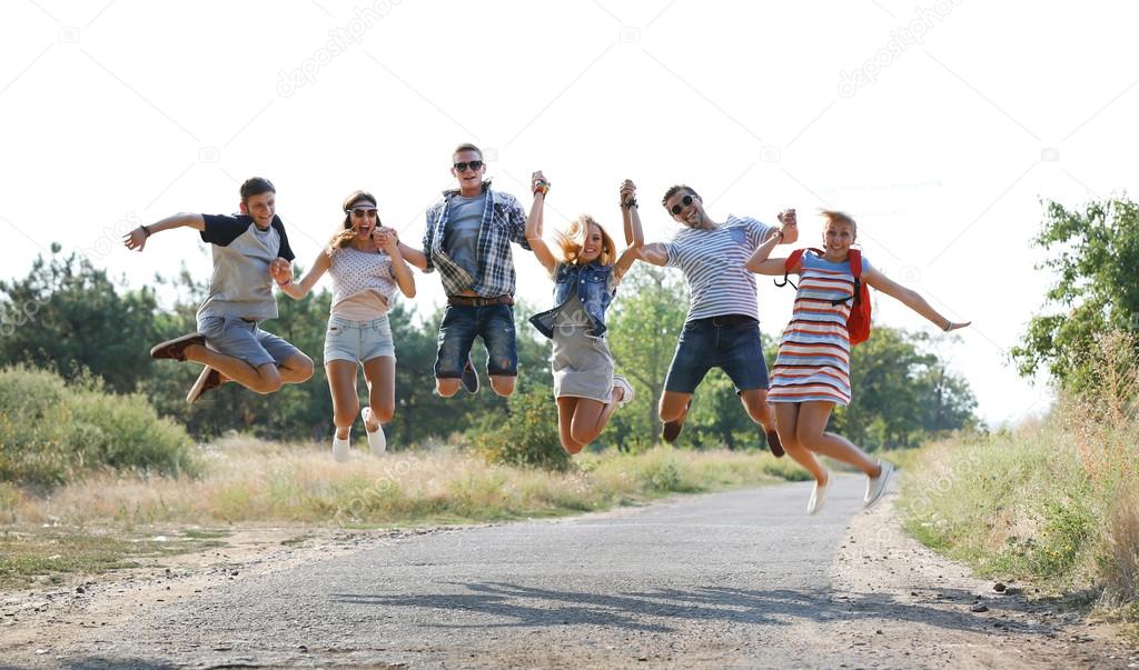 Happy friends jumping together, outdoors