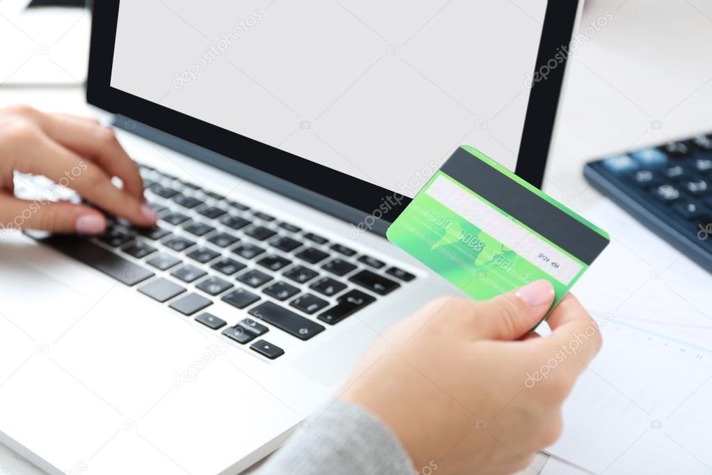 Concept for Internet shopping: hands with laptop and credit card