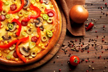 Ahşap masa üzerinde sebze ile lezzetli pizza