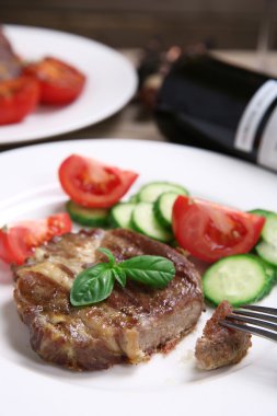 Kavrulmuş sığır filetosu ve ahşap arka plan üzerinde plaka üzerinde taze sebze