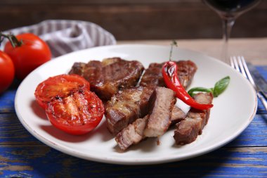 Kavrulmuş sığır filetosu ve ahşap arka plan üzerinde plaka üzerinde ızgara sebze