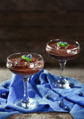Ahşap arka plan üzerinde bardaklarda çikolata tatlı