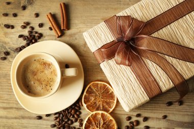 Güzel hediye, fincan kahve ve kahve taneleri ahşap arka plan üzerinde