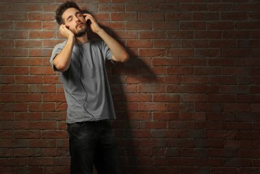 Kulaklıkla müzik dinleyen genç adam. 