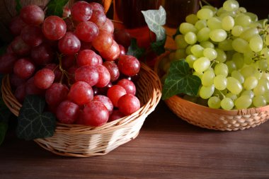 Grape in wicker bowls on wooden table