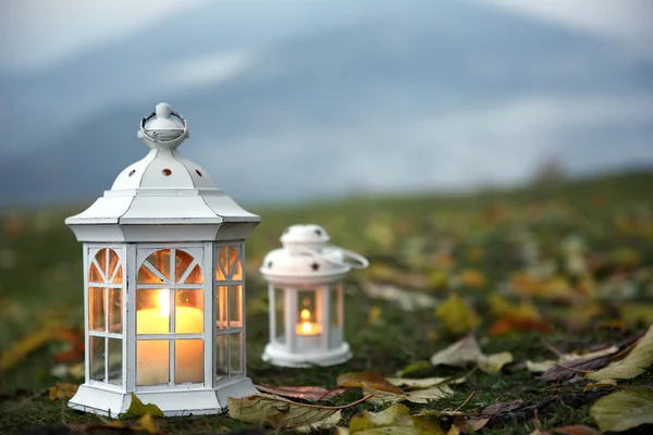 Lanterns with candles on grass — Stock Photo, Image