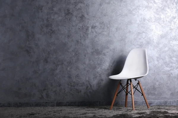 Стильная концепция с одним белым стулом на сером фоне — стоковое фото