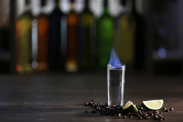 Branden cocktail met limoen en koffie bonen op tafel in een bar — Stockfoto