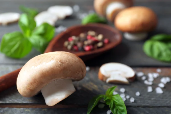 Fresh mushrooms, basil leaves and spices on wooden background — Stock Photo, Image