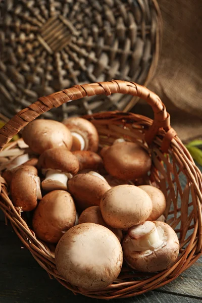 Cogumelos em cesta na superfície de madeira — Fotografia de Stock