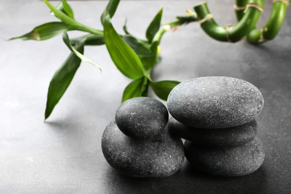 Pedras de spa quentes com bambu em fundo cinza, close-up — Fotografia de Stock