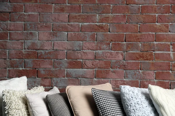 Multicolour pillows on brick wall — Stock Photo, Image