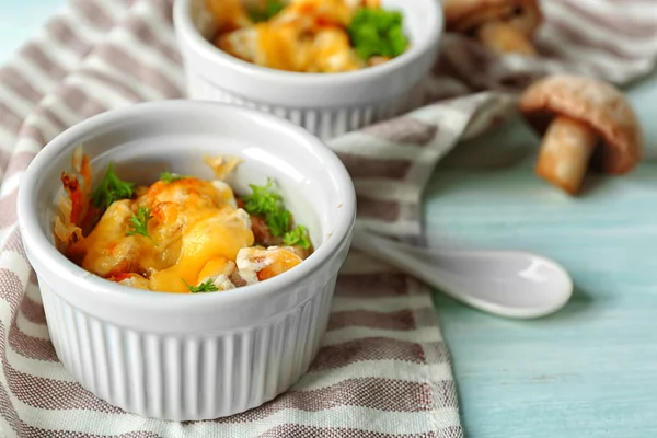 French dish julienne. Mushroom, chicken and cheese gratin in ceramic bowls, on wooden background — Stock Photo, Image