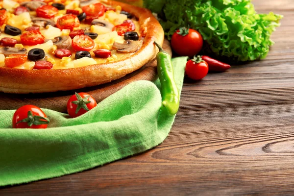 Pizza deliciosa com legumes e carne em guardanapo verde, close-up — Fotografia de Stock