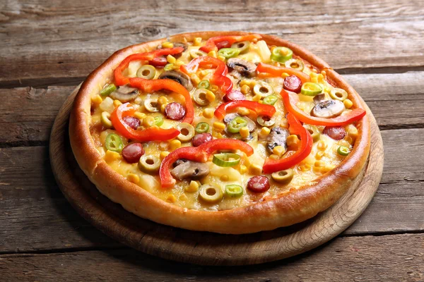 Вкусная пицца на деревянном фоне — стоковое фото