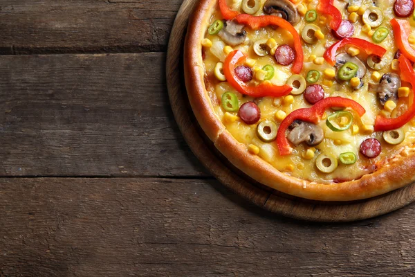 Deliziosa pizza su sfondo di legno — Foto Stock