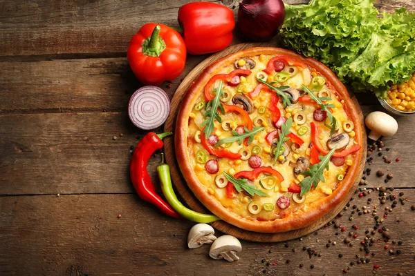 Смачна піца з овочами на дерев'яному фоні — стокове фото