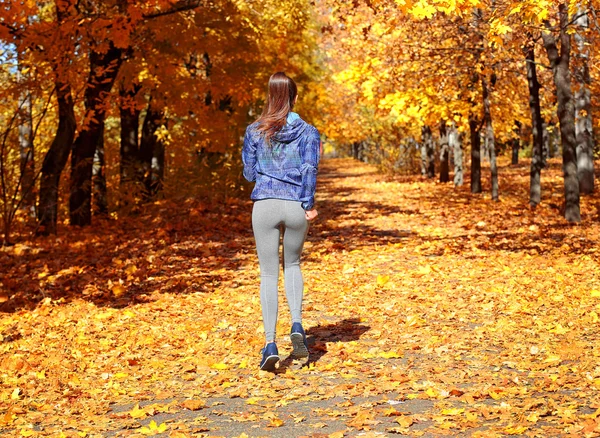 Woman jogging in autumn park — Stock Photo, Image