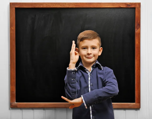 Leuke jongen die zich voordeed op schone blackboard — Stockfoto