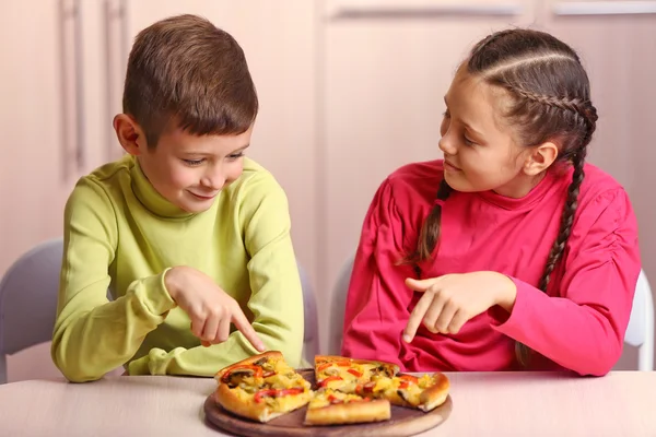 Děti jedí pizzu — Stock fotografie