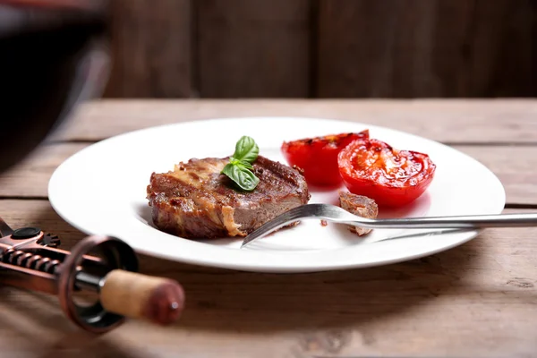 Смажене яловиче філе на тарілці, на дерев'яному фоні — стокове фото