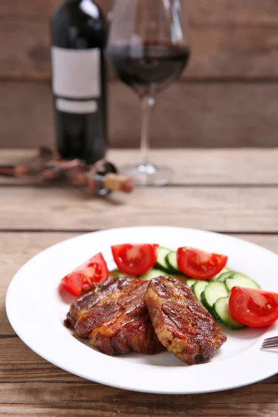 Filete de venado asado y verduras frescas en plato, sobre fondo de madera —  Fotos de Stock