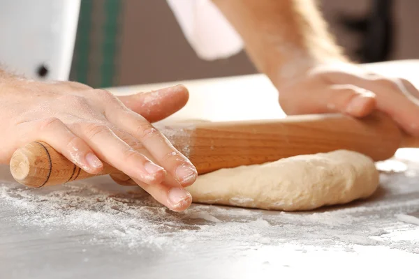 Ruční válení těsta na pizzu na dřevěném stole, detailní záběr — Stock fotografie