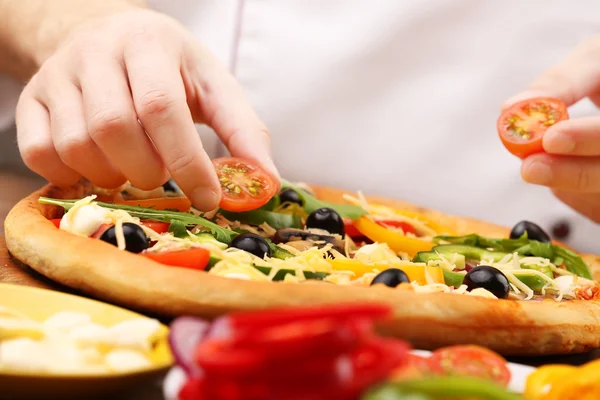 Koken maken heerlijke pizza in het restaurant, close-up — Stockfoto