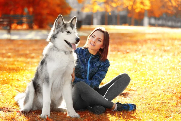 Mujer sentada con su perro en el parque — Foto de Stock