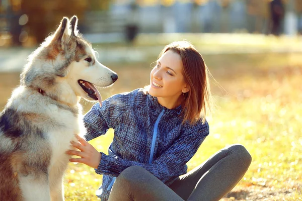 Kvinna sitter med sin hund i park — Stockfoto