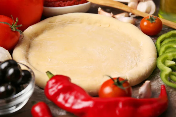 Pasta base e ingredienti per la pizza, in tavola — Foto Stock