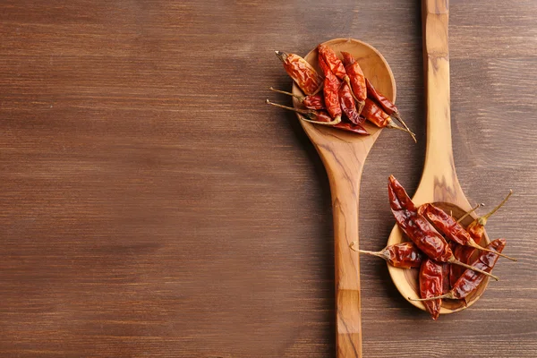 Två träskedar med torkade chili på bordet, närbild — Stockfoto
