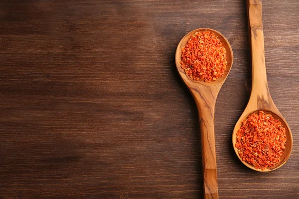 Two wooden spoons with spice on the table, close-up