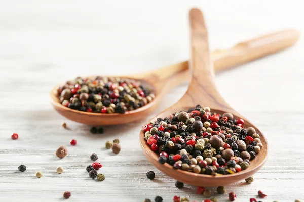 Duas colheres de madeira com pimenta na mesa, close-up — Fotografia de Stock