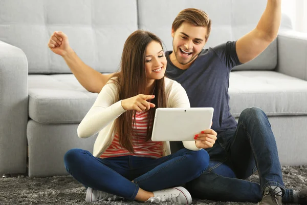 Jovem casal feliz usando tablet — Fotografia de Stock