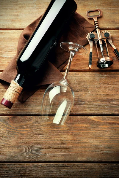 Láhev vína se sklem a vývrtka na dřevěné pozadí — Stock fotografie