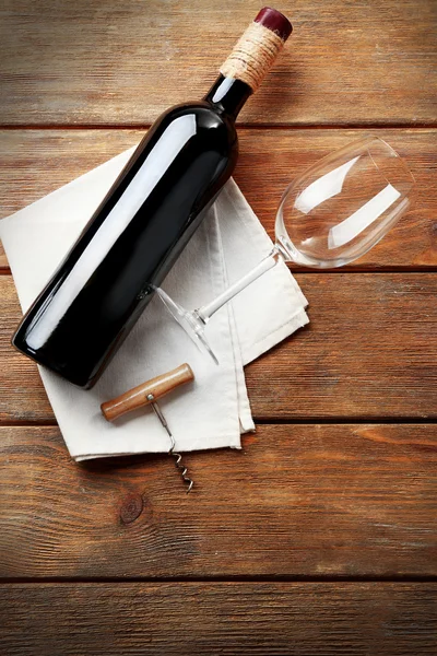 Botella de vino con vaso y sacacorchos sobre fondo de madera — Foto de Stock