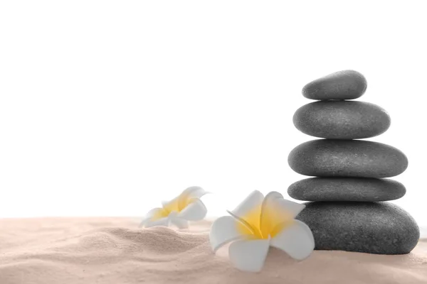 Några spa stenar med plumeria på sand, isolerad på vit — Stockfoto