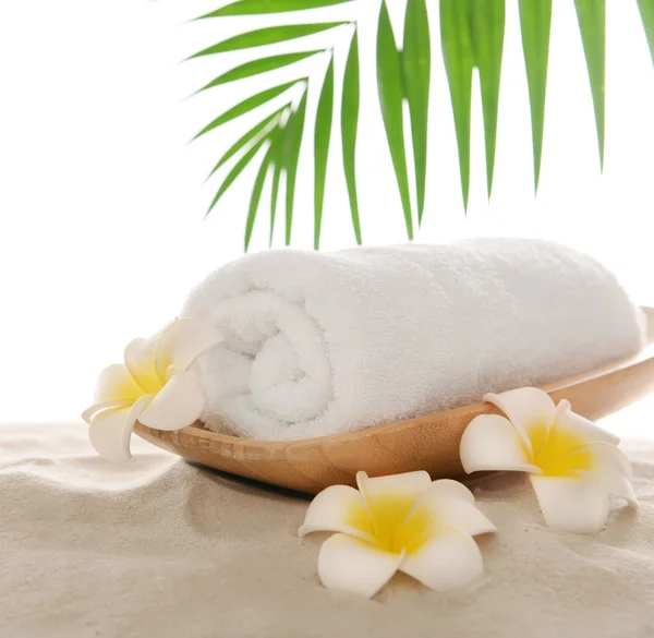 Курортное полотенце с сантехникой и бамбуком на песке, изолированное на белом — стоковое фото