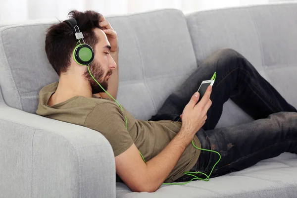 Young man listens music with headphones — Stock Photo, Image