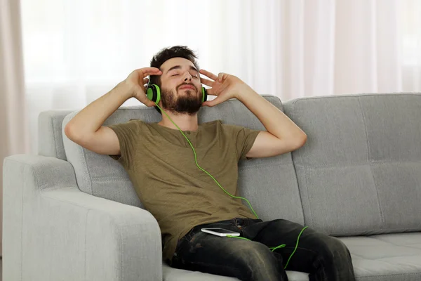 Joven escucha música con auriculares —  Fotos de Stock