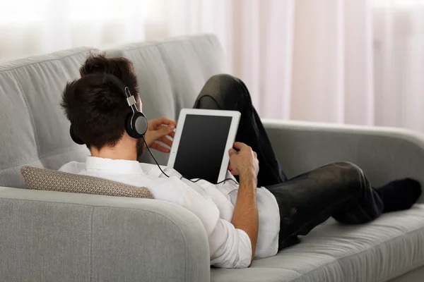 Joven escucha música con auriculares —  Fotos de Stock