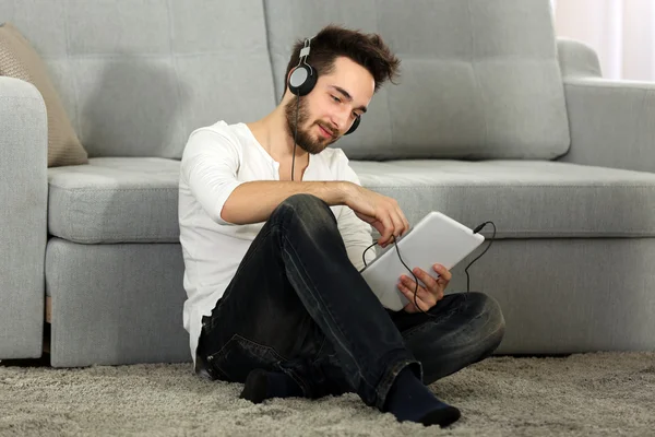 Joven escucha música con auriculares — Foto de Stock