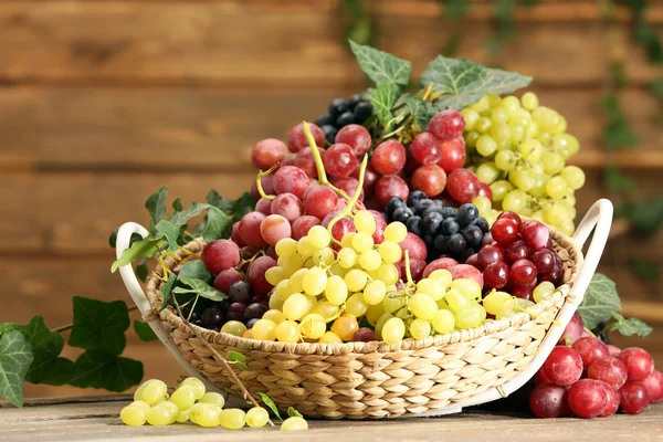 Grape in basket on wooden table — Stock Photo, Image