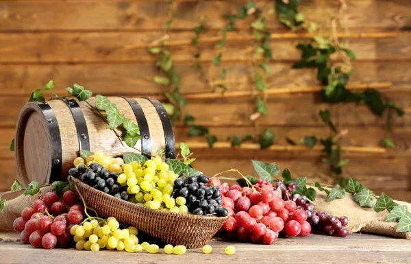 Grapes in bowl and barrel on wooden table — Stock Photo, Image