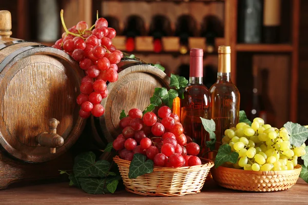 Druiven in kommen en vat op houten tafel — Stockfoto