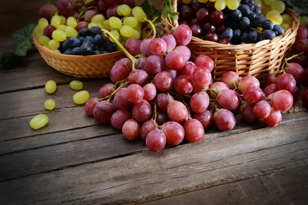 Grape in basket on wooden table — Stock Photo, Image